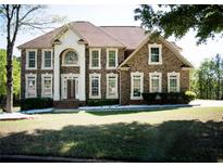 Traditional brick home with manicured lawn, columns, and arched entryway providing classic curb appeal at 2328 New Haven Pl, Conyers, GA 30094