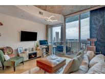 Living room with city views, modern decor, a work station, and a sliding glass door leading to a balcony at 400 W Peachtree Nw St # 3114, Atlanta, GA 30308