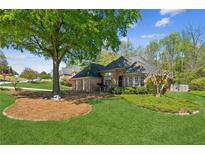 Charming single-story brick home with a well-manicured lawn and mature landscaping at 6382 Mountain Ridge Cir, Sugar Hill, GA 30518