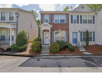 Charming two-story townhome featuring brick facade, grey shutters, and landscaped front yard at 984 Redwood Dr, Norcross, GA 30093
