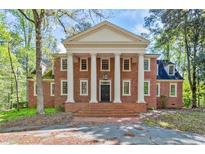 Stunning two-story brick home featuring grand columns, symmetrical design, and a stately entrance at 1961 River Forest Rd, Atlanta, GA 30327