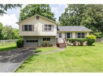 Charming split-level home featuring a well-maintained lawn, updated windows, and a convenient attached garage at 4424 Robinson St, Acworth, GA 30101