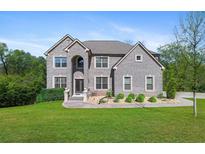 Imposing two-story gray brick home with well-manicured lawn, mature trees, and beautiful landscaping at 3206 Letha Woods Dr, Conyers, GA 30094