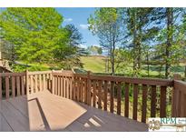Lovely deck featuring wood railings with a beautiful view of a golf course and mature trees at 420 Eagle Tiff Dr, Sugar Hill, GA 30518