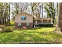 Charming split-level home featuring a welcoming front porch and a lush green lawn, perfect for outdoor enjoyment at 2755 Austin Ln, Jonesboro, GA 30236