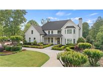 Stunning two-story home featuring manicured landscaping and a circular driveway at 9315 Prestwick Club Dr, Johns Creek, GA 30097
