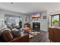 Cozy living room features a fireplace, hardwood floors, and large windows for natural light at 401 Berkeley Woods Dr, Duluth, GA 30096