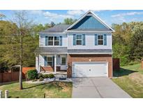 Charming two-story home with a brick facade, blue accents, and a well-manicured lawn at 327 Morning Frost, Canton, GA 30114