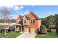 Charming two-story brick home with a well-manicured lawn and two-car garage at 4915 Bergen Ct, Cumming, GA 30040