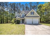 Charming two-story home featuring a two-car garage and a well-manicured lawn surrounded by mature trees at 432 Tanner Farm Dr, Rockmart, GA 30153