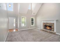 Bright living room with vaulted ceilings, a stone fireplace, and large windows at 432 Tanner Farm Dr, Rockmart, GA 30153