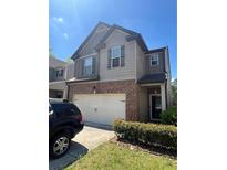 Two-story home with a two-car garage and brick accents, surrounded by a landscaped yard at 5903 El Segundo Way, Atlanta, GA 30349