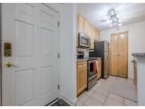 Compact kitchen featuring stainless steel appliances, granite countertops, and wood cabinets at 3203 Lenox Ne Rd # 32, Atlanta, GA 30324
