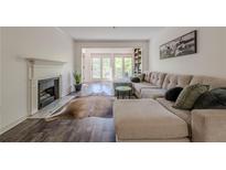 Bright living room with hardwood floors, fireplace, large sectional sofa, and door to the outside at 3203 Lenox Ne Rd # 32, Atlanta, GA 30324