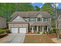 Charming two-story home features a two-car garage, brick facade, and beautifully landscaped front yard at 3447 Dogwood Pass, Lithonia, GA 30038