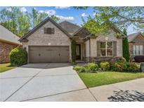 Charming brick and stone home with a two-car garage, manicured landscaping, and inviting curb appeal at 1227 Magnolia Path Way, Sugar Hill, GA 30518