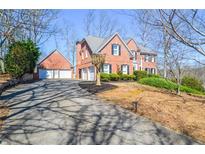 Beautiful two-story brick home with a three-car garage and well-maintained landscaping at 6450 Oak Valley Dr, Cumming, GA 30040