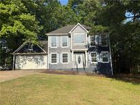 Charming two-story home with light blue shutters and an attached two-car garage, nestled among mature trees at 2570 Treasure Ct, Decatur, GA 30034