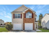 Charming two-story home with brick accents and a two-car garage, complemented by a well-manicured lawn at 5885 Waggoner Cv, Rex, GA 30273