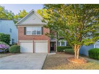 Charming two-story brick home with a two-car garage and a well-maintained front yard at 2545 Davenport Park Dr, Duluth, GA 30096