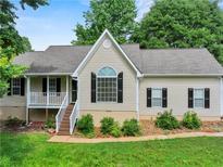 Charming home featuring a landscaped front yard, classic shutters, and a welcoming front porch at 5711 Parks Rd, Cumming, GA 30041