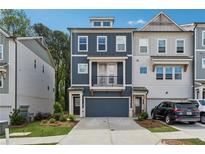 Charming three-story townhouse with a dark-blue facade and a balcony above the garage at 3533 Settlement Rd, Tucker, GA 30084