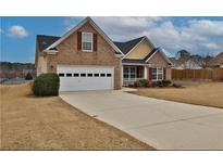 Charming brick home with a two-car garage, well-maintained lawn, and a welcoming entrance at 1104 Aqua Shore Dr, Mcdonough, GA 30252
