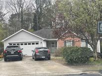 Charming single-story home with vinyl siding, brick accents, a two-car garage, and mature trees at 1116 Venice Cir, Lawrenceville, GA 30043