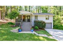Charming home with painted brick, front porch, steps up to front door, and well-manicured lawn and landscaping at 3046 Valley Cir, Decatur, GA 30033