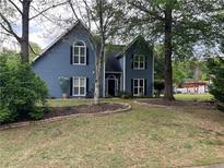 Charming blue two-story home featuring a lush landscaped yard and a welcoming front entrance at 3147 Pine Needle Sw Ct, Lilburn, GA 30047