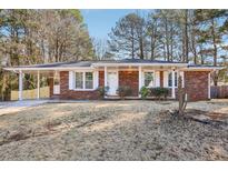 Charming single-story brick home with a covered carport and well-maintained front yard at 8298 Holly Dr, Jonesboro, GA 30238