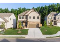 Charming two-story home featuring a stone facade, well-manicured lawn, and a welcoming front porch at 4568 Mantova Dr, Buford, GA 30519