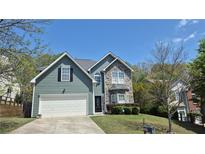 Charming two-story home featuring stone accents, vinyl siding and well-manicured lawn at 1015 Pebble Creek Trl, Suwanee, GA 30024