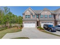 Two story brick townhome with a large driveway, two car garage, and well-manicured landscaping at 2378 Morgan Creek Rd, Buford, GA 30519