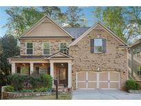 Charming two-story brick home featuring a welcoming front porch and a well-manicured front yard with beautiful landscaping at 358 Nature Brook Se Walk, Smyrna, GA 30082