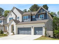 Charming two-story home featuring a brick facade, gray siding, and a two-car garage at 461 Maypop Ln, Woodstock, GA 30188