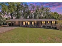 Charming one-story brick home with a well-manicured lawn, and a covered carport at 504 Baltimore Sw Ave, Lilburn, GA 30047