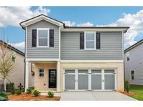 Charming two-story home with gray siding, black shutters, and a light stone garage with a three-car gray door at 2762 Aralynn Way, College Park, GA 30337