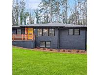 Charming home featuring a newly painted brick exterior, inviting porch, and well-manicured lawn at 3661 W Potomac Dr, East Point, GA 30344