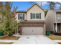 Charming two-story home with a brick-accented garage and well-maintained landscaping at 3095 Bonnes Dr, Lithonia, GA 30038