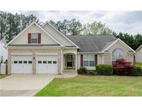 Charming single Gathering home features a two car garage, manicured lawn, and inviting front porch at 854 Nichols Landing Ln, Dacula, GA 30019