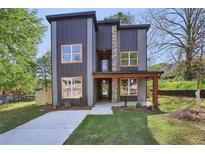 Contemporary two-story home with large windows, a stone facade, modern siding, and a well-manicured lawn at 1002 Coleman Sw St, Atlanta, GA 30310