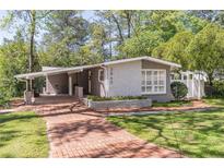 Charming gray brick home with brick walkway, manicured lawn, and carport at 3860 Carlton Dr, Atlanta, GA 30341