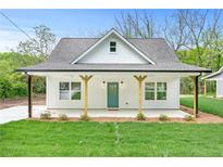 Charming single-story home featuring a covered front porch, green lawn, and a teal front door at 5232 W Mountain St, Stone Mountain, GA 30083