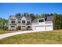 Stunning two-story modern farmhouse featuring a three-car garage and manicured lawn at 4059 Yellow Creek Trl, Cumming, GA 30028