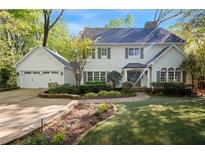 Charming two-story home featuring a lush landscaped yard, attached garage and inviting front porch at 4477 Jett Nw Rd, Atlanta, GA 30327