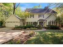 Charming two-story home featuring a well-manicured lawn, attached garage, and inviting front entrance with beautiful landscaping at 4477 Jett Nw Rd, Atlanta, GA 30327