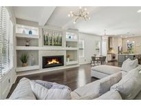 Bright living room featuring a cozy fireplace, built-in shelving, and modern lighting at 823 Canterbury Overlook, Atlanta, GA 30324