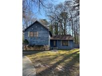 Charming two-story home featuring a stone accent wall and mature trees, perfect for serene living at 6846 Cherry Log Pl, Austell, GA 30168