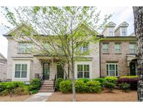 Charming brick townhome featuring a landscaped front yard and inviting entryway at 1323 Faircrest Way, Suwanee, GA 30024